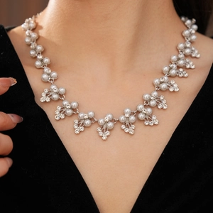 Détail du collier de mariée avec perles blanches et cristaux sur monture argentée