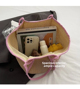 Detail shot of the large capacity straw bag interior holding tablet, book and umbrella