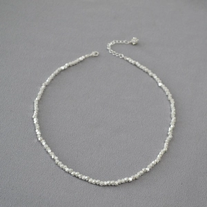 Macro shot of silver irregular faceted beads necklace with adjustable extension chain