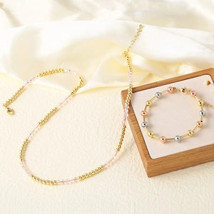 Elegant beaded crystal necklace with tri-color gold bracelet on white satin display