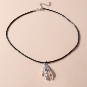 Macro shot of silver skeleton hand pendant on black cord with adjustable metal chain