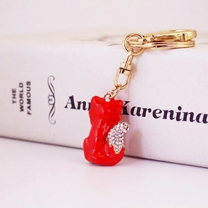 Sparkling red fox crystal keychain with gold plating and rhinestone tail on a book