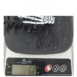 Détail de la pince à cheveux main de squelette avec résille, pesant 11g sur balance