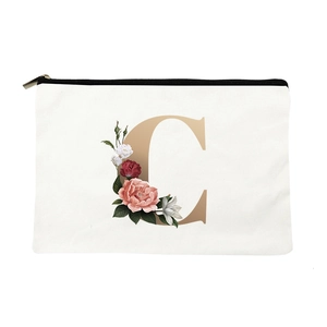 White canvas makeup bag with golden letter C and floral rose pattern on white background