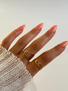 Détail d'un ensemble de bagues en or 18K avec lignes irrégulières et design de cœur