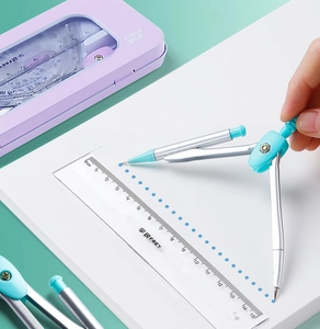Detail showing hand using silver metal compass with ruler from a 7-piece stationery set