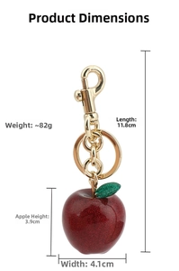 Close-up of red glitter apple keychain with golden hardware and size measurement markings