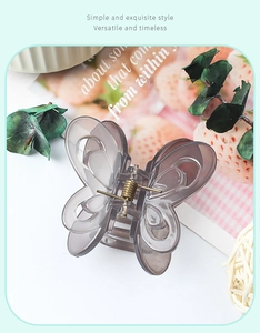 Detail of elegant translucent smoky gray butterfly hair claw clip with gold metal spring