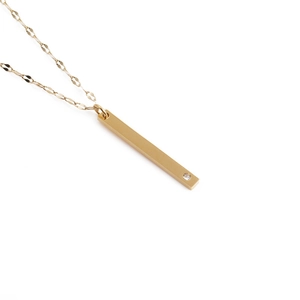 Minimalistische goldene Titanstahl-Halskette mit Stabanhänger und einem kleinen Diamanten