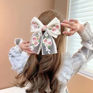 Cream lace bow hair clip with pink floral embroidery and long elegant streamers