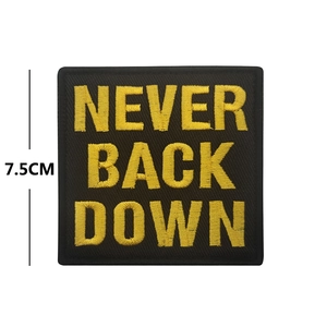 Tactical embroidered patch featuring 'NEVER BACK DOWN' slogan in gold on black
