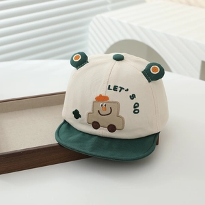 Close-up of baby baseball cap featuring cartoon car embroidery and soft green brim detail