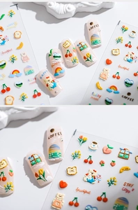 Close-up of 3D embossed nail art stickers with bear, rainbow, and cherry patterns