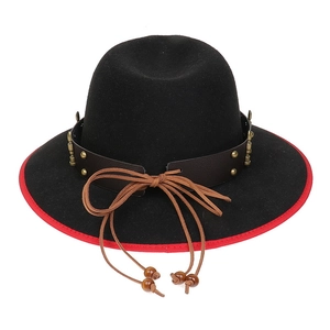 Detail of western cowboy hat featuring red trim, leather band, and golden studs decoration