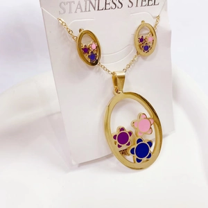 Detail of golden stainless steel necklace and earrings with colorful floral inlay