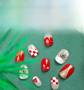 Detail of Christmas press-on nails with red, white, and green holiday patterns