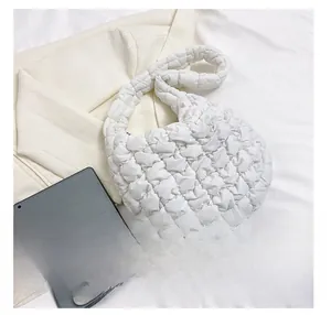 Detailed size comparison showing white quilted cloud bag holding a tablet and smartphone
