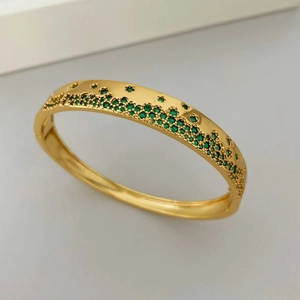 Vue macro d'un bracelet doré orné de zircons verts sertis avec un design raffiné