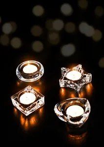 Macro detail of geometric clear glass candle holders with burning tealights set of 4