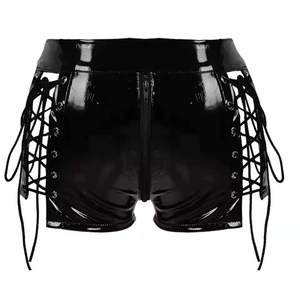 Dettaglio degli shorts in pelle verniciata nera con lacci laterali e cerniera frontale