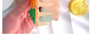 Détail d'une pince à cheveux créative en forme de carotte en acrylique orange vif