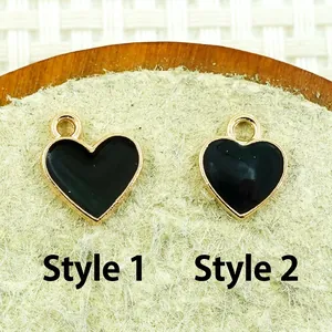 Detailed close-up of heart-shaped alloy charms with black enamel finish for DIY jewelry making