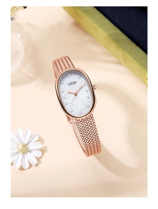 Detail of rose gold oval watch with mother-of-pearl dial and woven metal strap