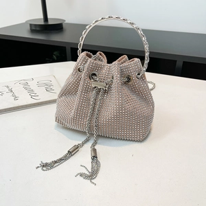 Vue détaillée du sac seau beige rose orné de strass argentés et de glands en chaîne