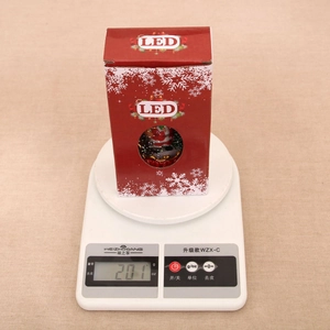 Detailed view of Santa LED candle light in festive red packaging weighing 201g