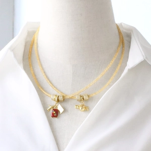 Gouden mesh ketting met rode koffer, vliegtuig en wereldbol hangers voor reizigers