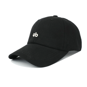 Detailed close-up of white letter ab embroidery on black cotton twill baseball cap