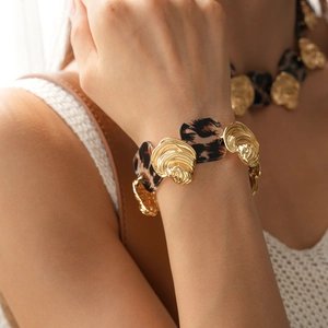 Detail of leopard print resin and gold irregular metal segments on adjustable bracelet