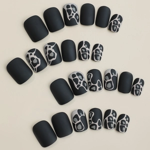 Matte black press-on nails set with animal print patterns in short square shape