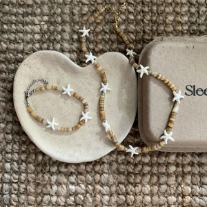 Resort style beaded necklace and bracelet set with starfish charms on a ceramic tray