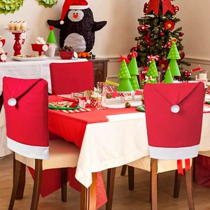 Detail of red and white Christmas chair covers with decorative pompoms in a dining setting
