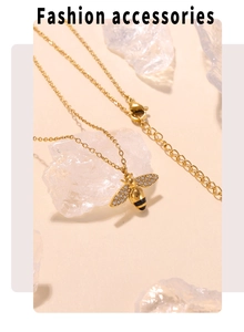 Detail of gold bee pendant with white zircons and black enamel on a fine chain necklace