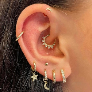 Golden celestial ear jewelry set with zircon star and moon pendants on a female model