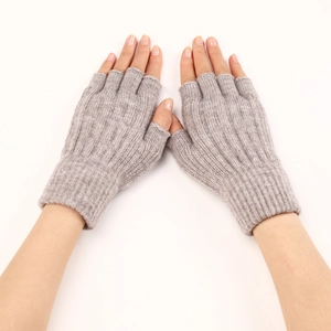 Detail view of grey knit fingerless gloves featuring classic cable stitch pattern