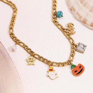 Detail of 18K gold Figaro necklace featuring ghost, pumpkin, and starfish charms