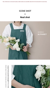 Detail of wide shoulder strap green apron with large front pocket and cotton linen texture