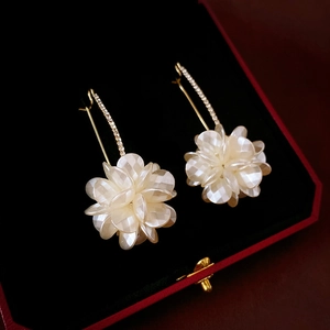 Orecchini a fiore in acrilico bianco con ganci dorati e diamanti su velluto nero