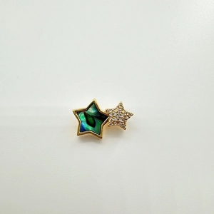 Macro shot of gold star necklace pendant with iridescent shell inlay and micro diamonds