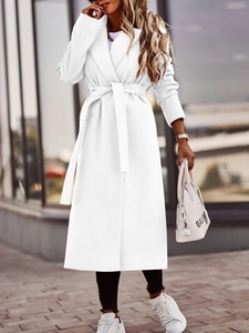 Detail of elegant white wool coat featuring a wide lapel and waist-defining tie belt