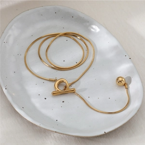 Minimalist gold snake chain Y-necklace with OT toggle clasp and smooth metal ball pendant