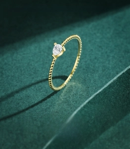 Detailed view of pear-shaped zircon on golden 925 sterling silver beaded ring