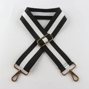 Detail of 5cm wide black and white striped bag strap with bronze metal lobster clasps