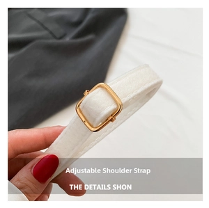 Close-up of adjustable white shoulder strap with polished gold square metal buckle
