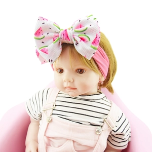 Detail of pink nylon headband with large watermelon print bow on a baby model