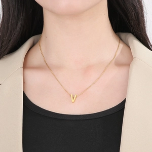 Minimalist gold stainless steel V letter pendant necklace worn by a fashion model