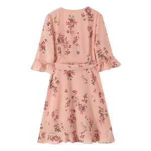 Close-up of pink floral dress featuring elegant ruffle sleeves and waist tie detail